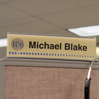 Cubicle nameplate installed above a cubicle panel for easy identification in an office workspace