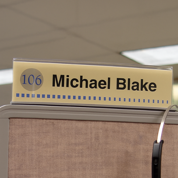 Cubicle nameplate installed above a cubicle panel for easy identification in an office workspace